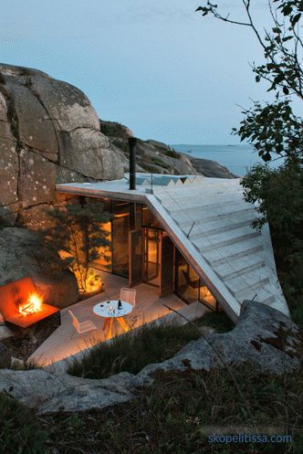 House with transparent walls on sunny rocky shores in Sandefjord, Norway